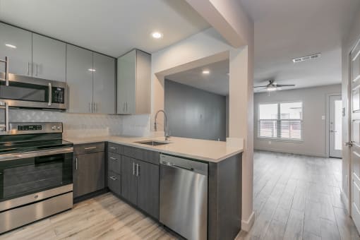 Designer kitchen with quartz countertops and stainless-steel appliances in Dallas apartment