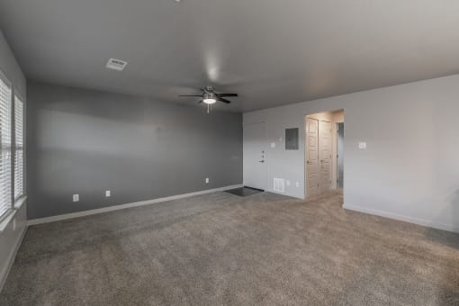 Modern open-concept living room with ceiling fan and wood-style floors at Reserve on Abrams Dallas
