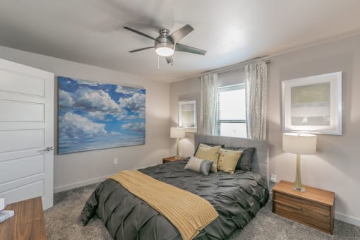Stylish bedroom with ceiling fan and natural light at Reserve on Abrams Dallas