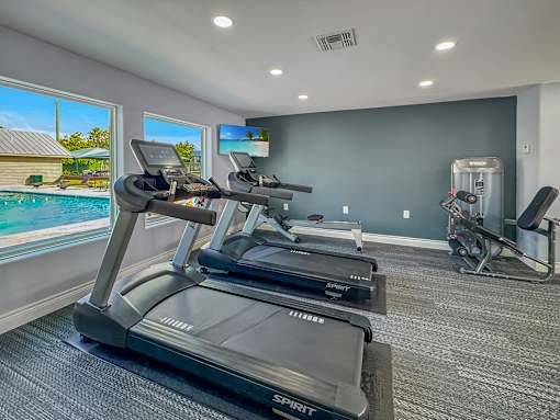 Treadmills facing pool view in gym – Borders Apartments Brownsville TX