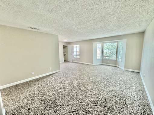 Large living room with grey carpet and bright natural light at Greenbriar Place 55+ Senior Apartments in Corpus Christi.