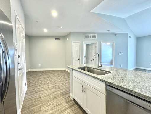 A kitchen with a sink and a refrigerator.