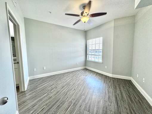 A room with a ceiling fan and a door.