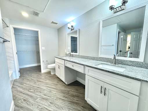 A bathroom with a sink, mirror, and toilet.