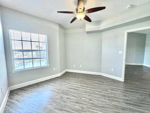 A room with a ceiling fan and a window.