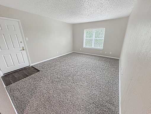 A room with a door, window, and carpeted floor.