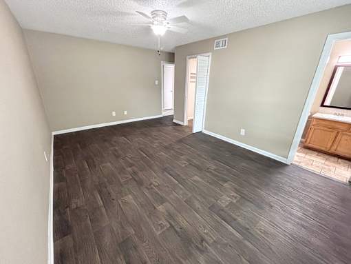 A room with wooden flooring and a ceiling fan.