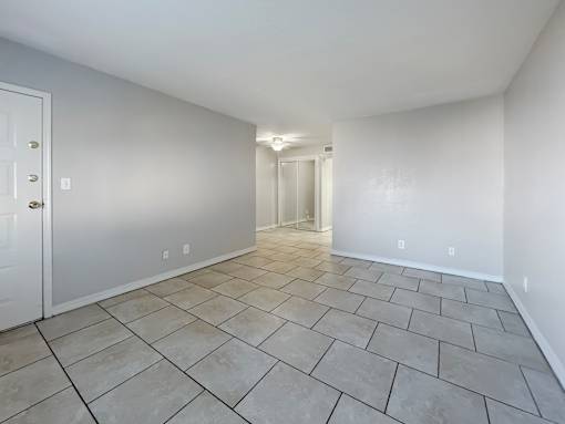 A room with a tiled floor and a white door.