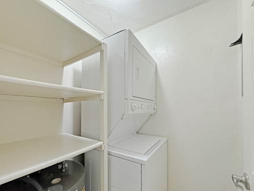 A white washing machine sits in a small laundry room.