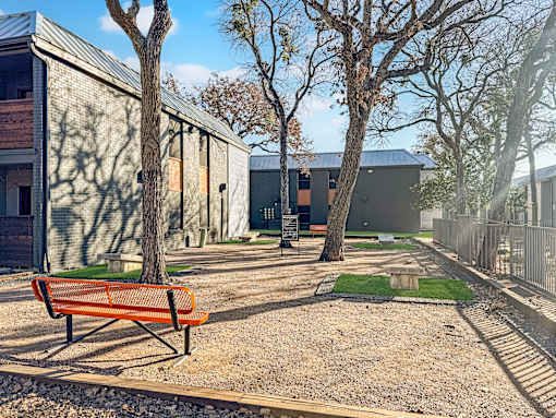 Corn hole area with tables under trees at Verano Oaks Apartments in Hurst, TX