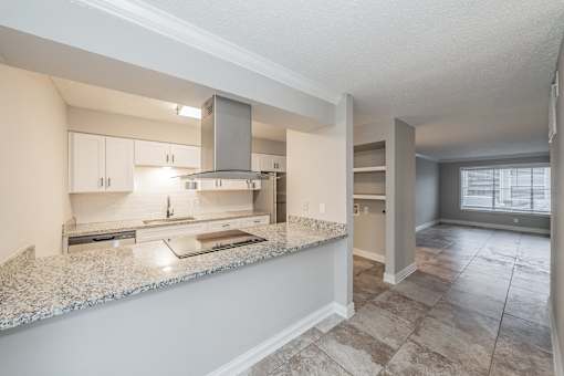 Apartment kitchen featuring upgraded appliances and lighting