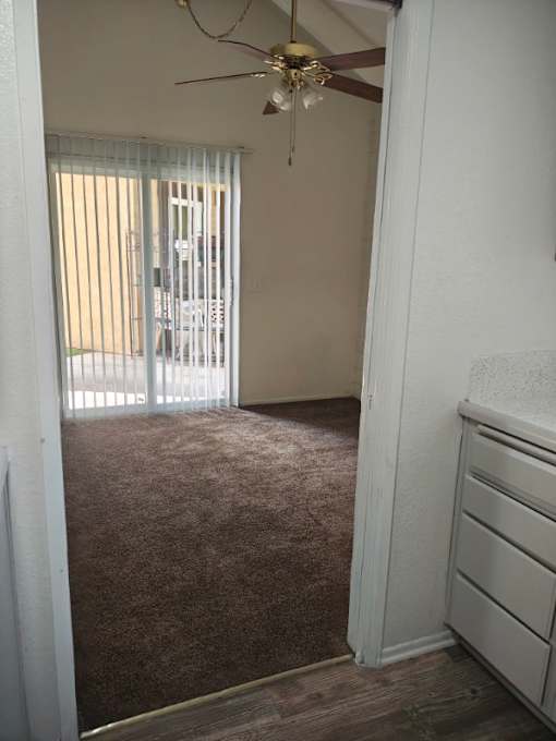 A hallway with a bedroom at the end at Raintree Apartments, CA 92346