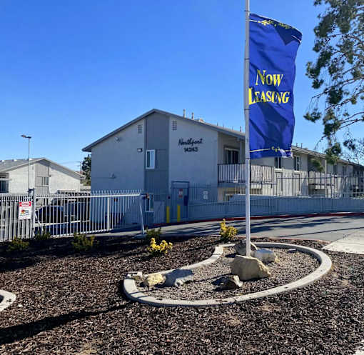 A sign in front of a building that says at Raintree Apartments, CA 92346