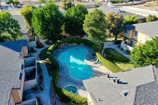 an aerial view of a swimming pool and hot tub in a backyard of a home