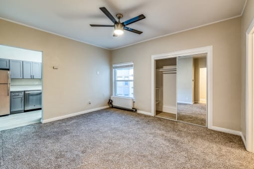 a bedroom with a ceiling fan and a large mirror