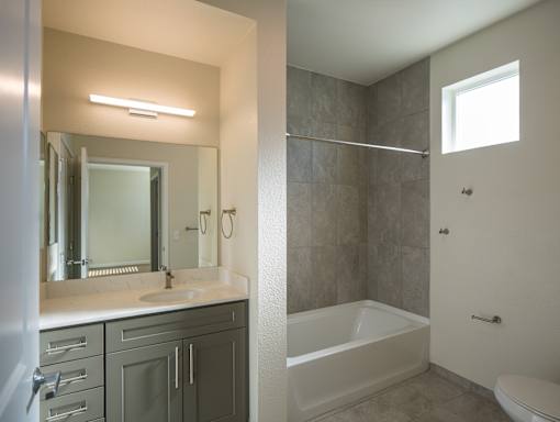 A bathroom with a white sink and a white bathtub.
