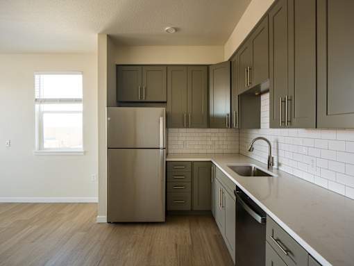 A kitchen with a stainless steel refrigerator and dark wood cabinets.