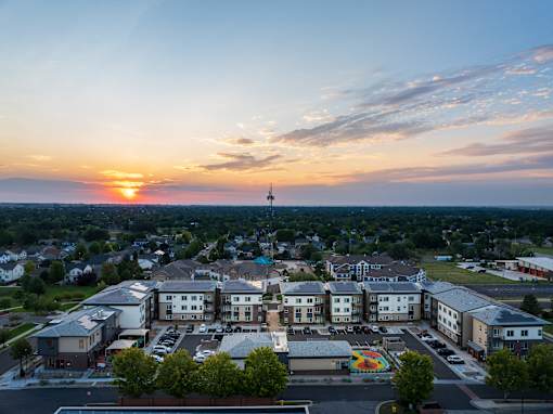 A sunset view of a town with a large building in the foreground.