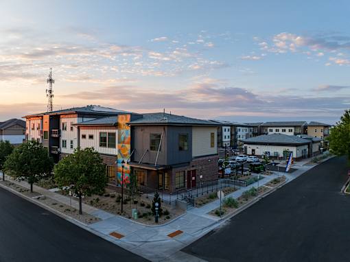 A street view of a modern building with a colorful mural on the side.