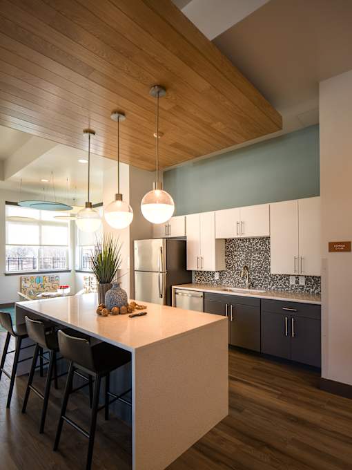 A kitchen with a wooden ceiling and a white counter.