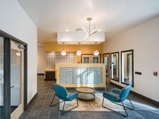 A modern office lobby with a reception desk and two chairs.