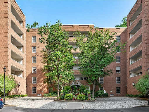 A brick building with a courtyard in front.