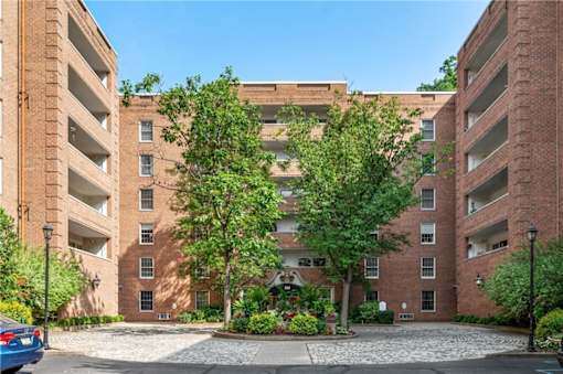 A large brick building with a courtyard in front.