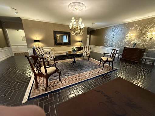 A living room with a couch, chairs, and a rug.
