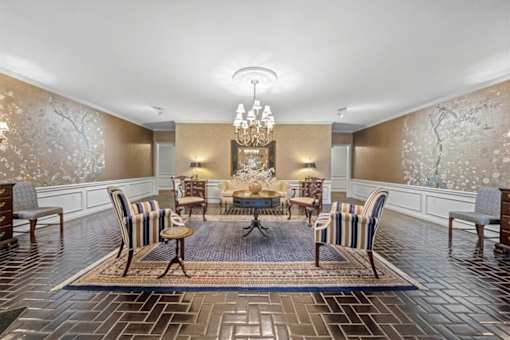 A dining room with a large table surrounded by chairs.