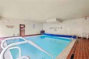 A small indoor swimming pool with a blue bottom and white ladders.