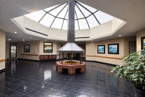 A large atrium with a black tiled floor and a glass roof.