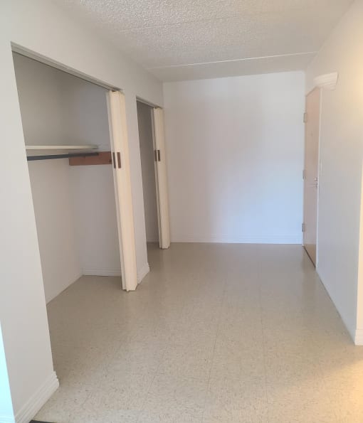an empty room with a closet and a tiled floor