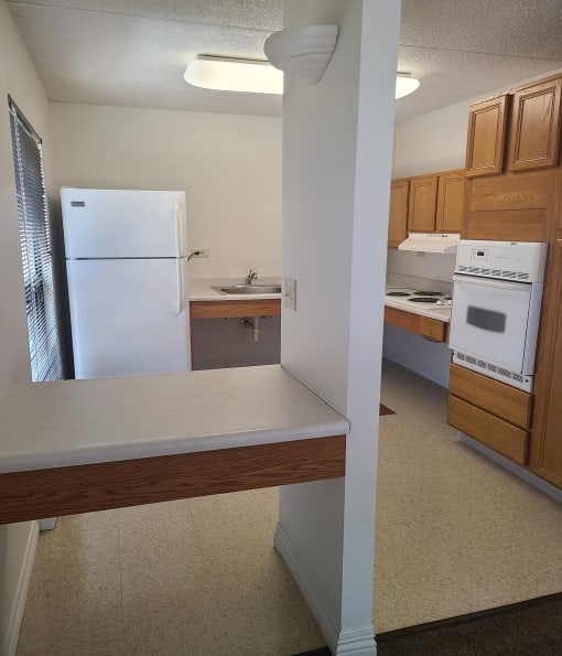 a kitchen with a white refrigerator freezer next to a white stove top oven