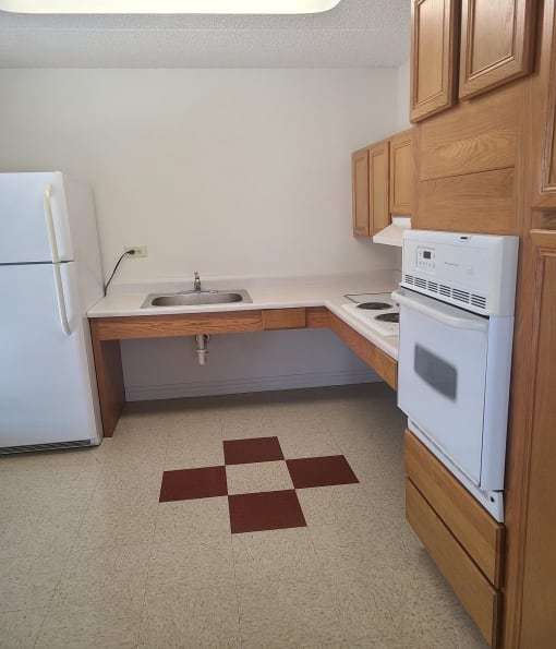 a small kitchen with a white refrigerator freezer next to a white stove top oven