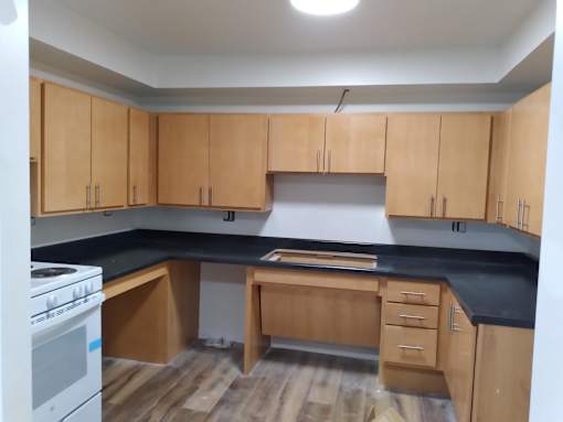 A kitchen with wooden cabinets and a white stove.