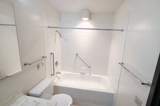 A white bathroom with a toilet, sink, and bathtub.