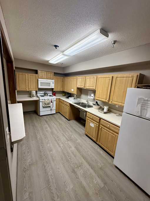 A kitchen with wooden cabinets and a white refrigerator.