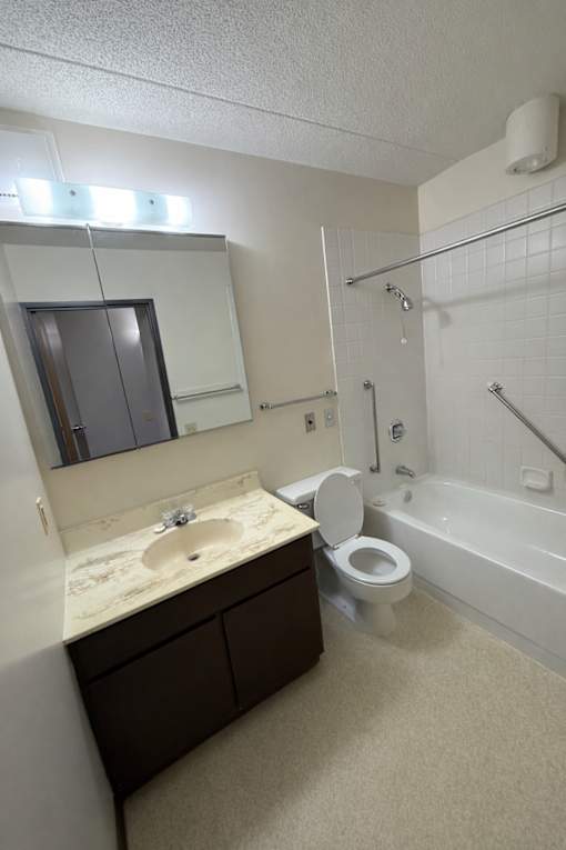 A bathroom with a sink, toilet, and bathtub.