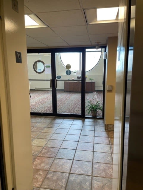 a hallway with an open door and tiled floor