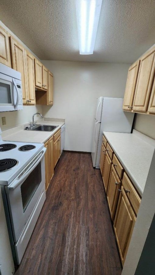 a kitchen with a white stove top oven next to a refrigerator