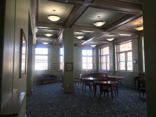 a large room with a row of windows and tables and chairs
