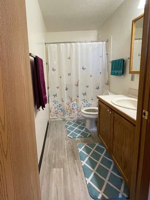 A small bathroom with a toilet, sink, and shower curtain.