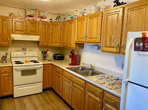 A kitchen with wooden cabinets and a white refrigerator.