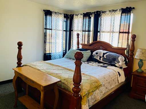A bed with a wooden frame and a wooden bench in front of it.