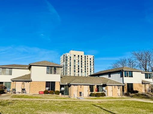 A row of houses with a high rise building in the background.