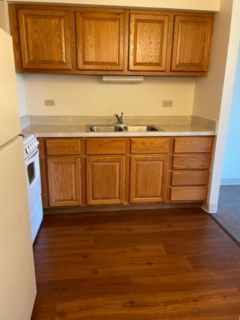 a kitchen with wooden cabinets and a white stove