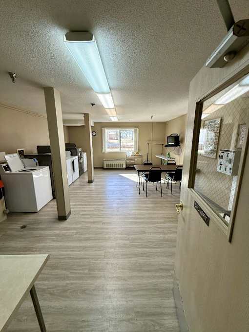 A kitchen area with a dining table and chairs.