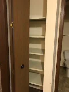 A brown door with a glass panel and a black knob.