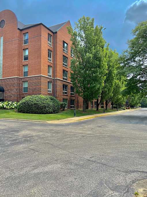 A red brick building with a green lawn in front.
