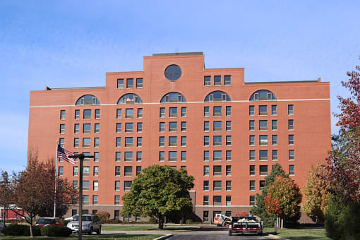 a large brick building with many windows and an american flag in front of it